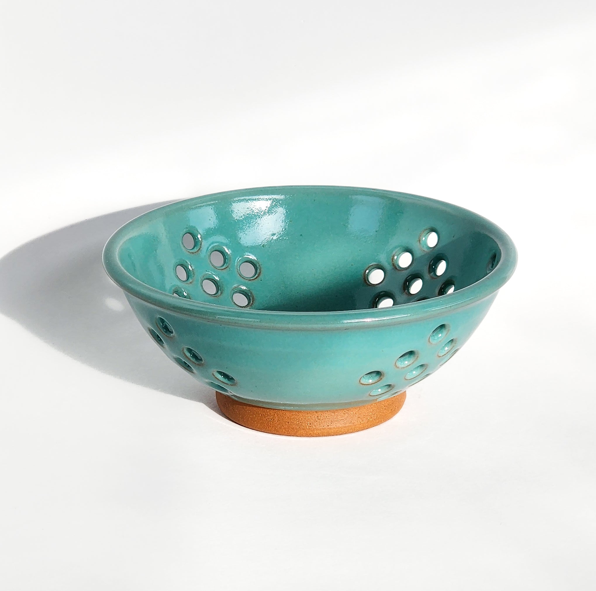 Image: Clinton Pottery's Handmade Small Colander in Sky Blue – A serene and practical 2.25 cup colander, expertly crafted. This Sky Blue piece adds a touch of tranquility to your kitchen, reminiscent of clear skies and calm waters. Ideal for washing berries and smaller items, it seamlessly combines style with functionality. Machine washable for convenience, it's the perfect choice for those who appreciate practicality and aesthetics in a soothing, classic hue.