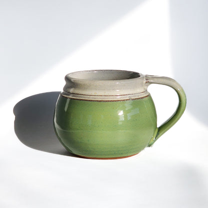 Image: Clinton Pottery's 24 oz Cereal/Soup Mug in Bud Green – A vibrant and versatile addition to your kitchen, this machine washable mug seamlessly blends artistry with functionality. The refreshing Bud Green color adds a touch of nature's vitality, reminiscent of spring foliage and new beginnings. Perfect for enjoying your favorite cereal or soup, bringing a pop of color to your dining experience.