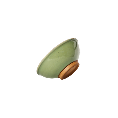 Image: An extra small ceramic bowl in a vibrant bud green color, reminiscent of fresh spring foliage. The bowl features a smooth glaze and rounded edges, offering a pleasing aesthetic and comfortable grip. With a size of 1 cup, it's ideal for holding small servings of food or ingredients