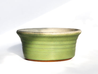 Image: Clinton Pottery's Handmade 1 Cup Flat Bottom Bowl in Bud Green – A vibrant and versatile addition to your kitchen, showcasing a perfect blend of artistry and functionality. The refreshing bud green color serves as a reminder of spring, summer grass, and new buds on plants and trees, adding a seasonal touch to this machine washable bowl. Ideal for serving snacks, cooking prep, or charming storage solutions.