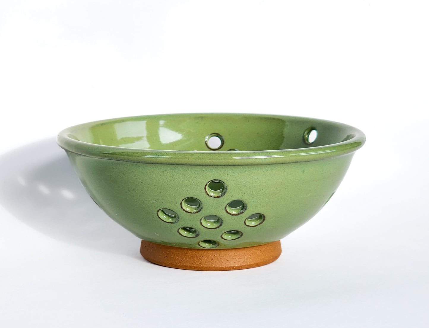 Image: Clinton Pottery's Handmade Small Colander in Bud Green – A charming 2.25 cup colander, expertly crafted to embody the freshness of spring. Ideal for washing berries and smaller items, this soothing Bud Green piece seamlessly combines style with functionality. Machine washable for convenience, it's the perfect choice for those who appreciate practicality and aesthetics in a vibrant hue that captures the essence of the warmer seasons.