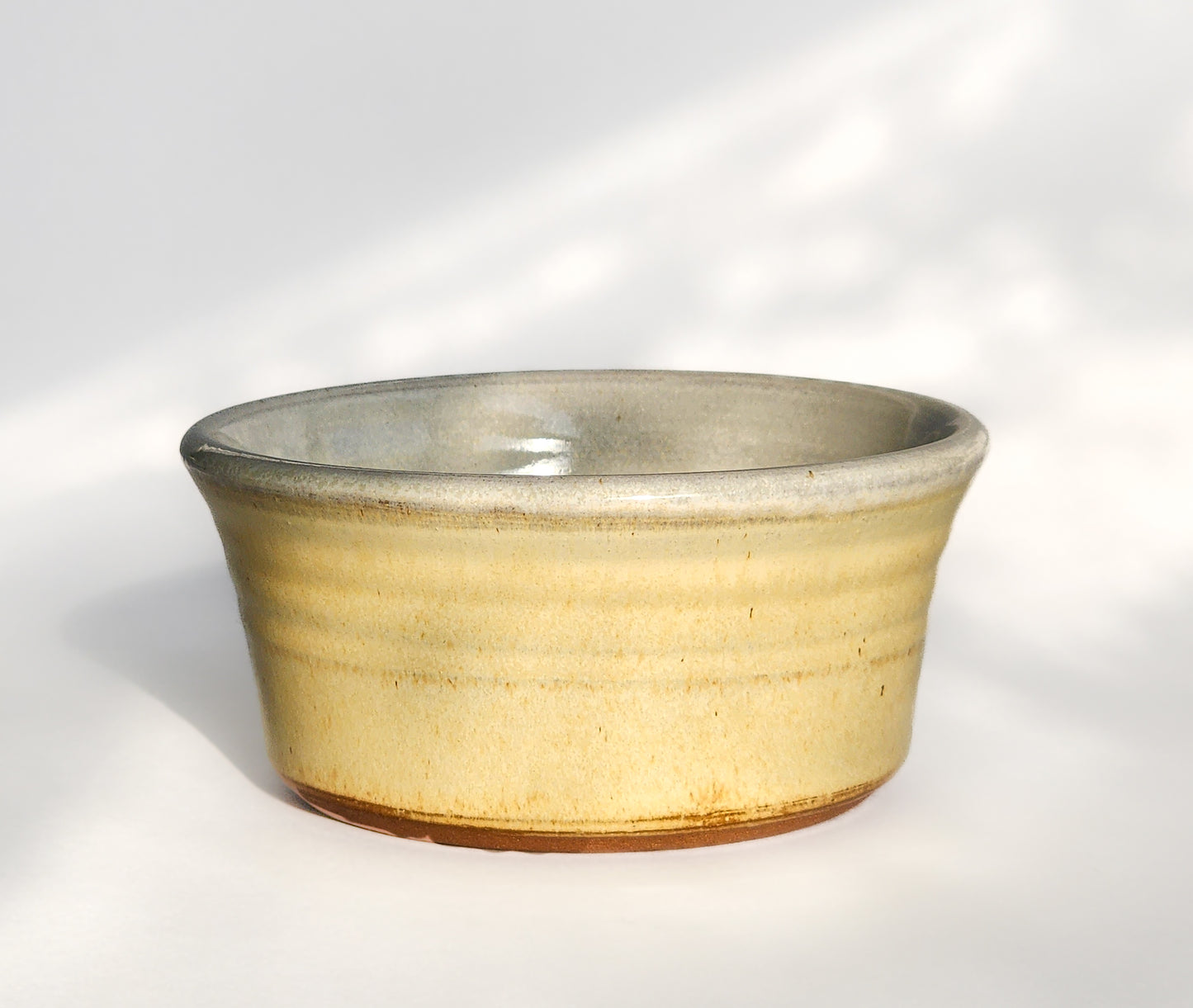 Image: Clinton Pottery's Handmade 1 Cup Flat Bottom Bowl in Butter Yellow – A ray of culinary sunshine, this machine washable bowl seamlessly marries artistry with practicality. The gentle butter yellow color evokes warmth and comfort, reminiscent of golden fields and cozy kitchens. Perfect for serving snacks or infusing your space with a delightful touch of charm