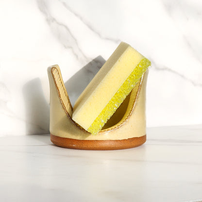 Image: Clinton Pottery's Handmade Sponge Holder in Butter Yellow – An inviting and practical kitchen accessory, expertly crafted by artisans. This durable stoneware holder, in soothing Butter Yellow, brings a touch of soft warmth to your kitchen. Designed to securely hold your sponge and prevent water spread, it keeps your counters and sink area tidy. Machine washable for convenience, seamlessly combining functionality with the gentle charm of Butter Yellow.