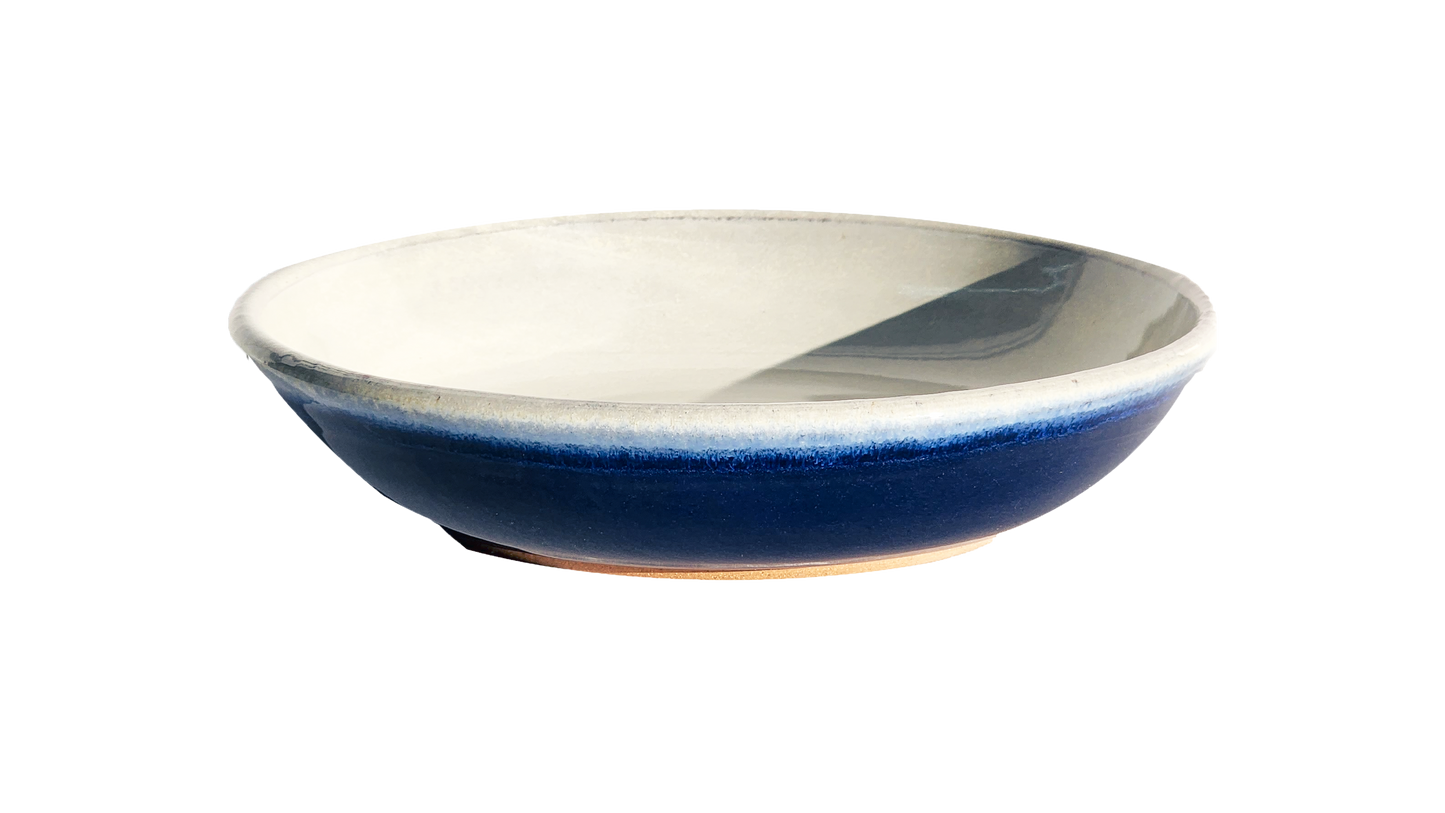 Image: A large pasta dish with a diameter of 10 inches, meticulously handmade by Clinton Pottery, showcasing a rich cobalt glaze. The intense blue hue of the glaze exudes sophistication and elegance, making it an exquisite option for presenting generous portions of pasta dishes with a modern twist.