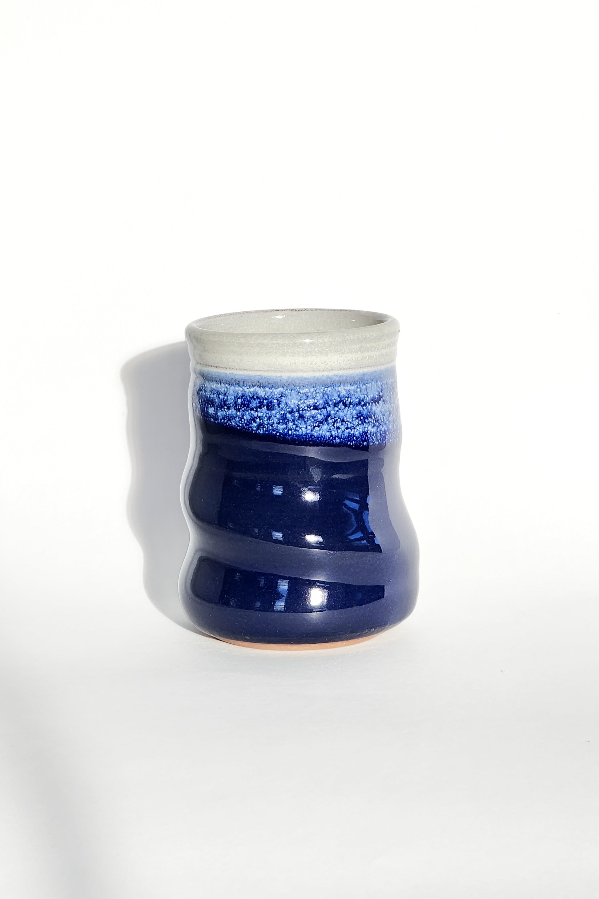 Image: Clinton Pottery's 15 oz Large Tumbler in Cobalt Blue – A visually striking addition with a cool, curvy design for a comfortable grip. This machine washable tumbler, crafted with care, adds contemporary elegance. The deep Cobalt Blue color brings richness, reminiscent of clear skies and ocean depths.