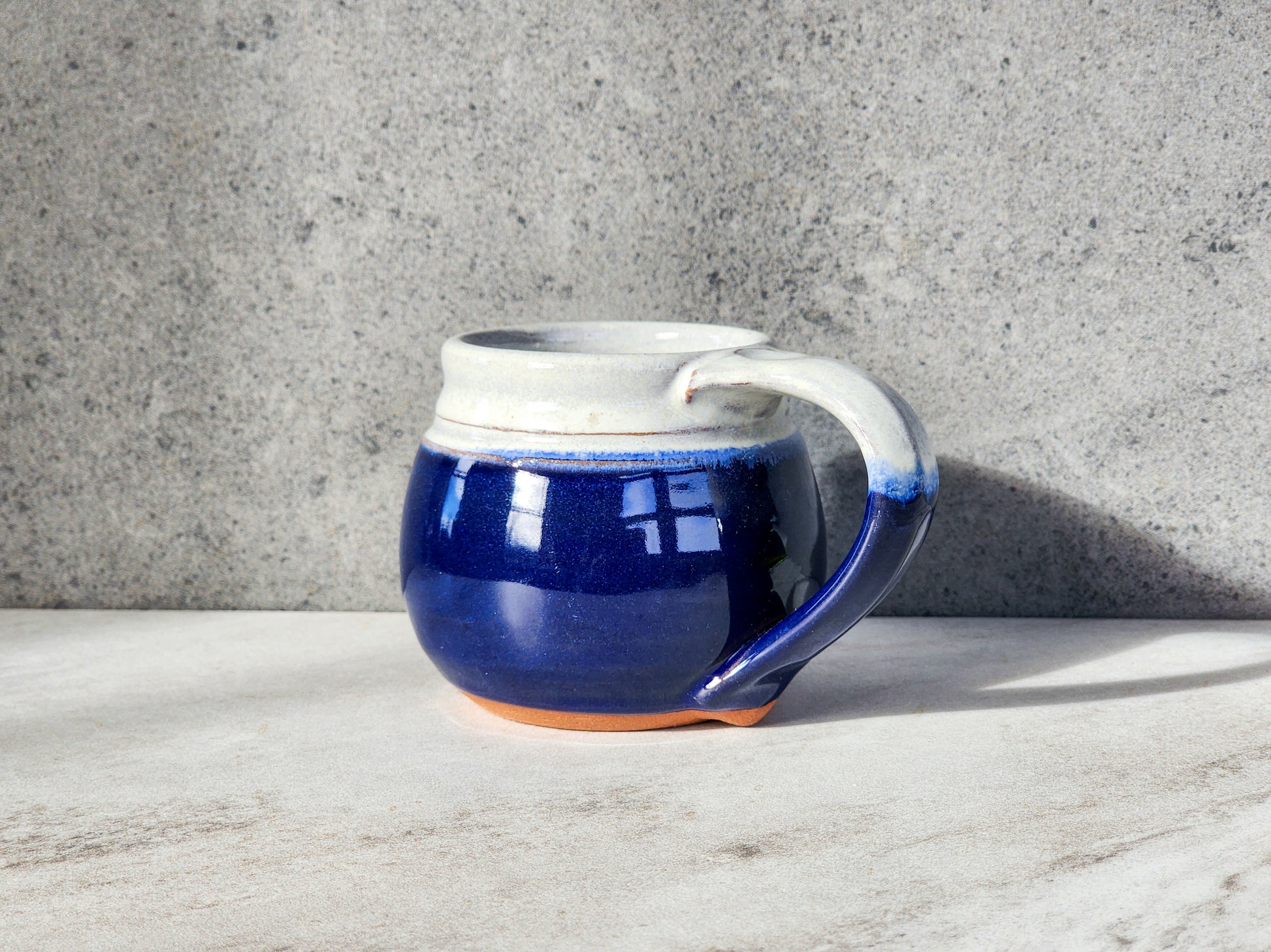The Cobalt small mug from Clinton Pottery exudes sophistication and depth. With a sleek design and vibrant cobalt blue hue, this mug adds a touch of elegance to your coffee or tea routine. Crafted for comfort and style, it's perfect for savoring your favorite hot beverage. Elevate your drinking experience with the Cobalt small mug, a timeless addition to your kitchen essentials.