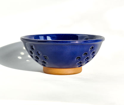  Image: Clinton Pottery's Handmade Small Colander in Cobalt – A bold and practical 2.25 cup colander, expertly crafted. This deep Cobalt piece adds a touch of sophistication to your kitchen, reminiscent of serene waters and timeless elegance. Ideal for washing berries and smaller items, it seamlessly combines style with functionality