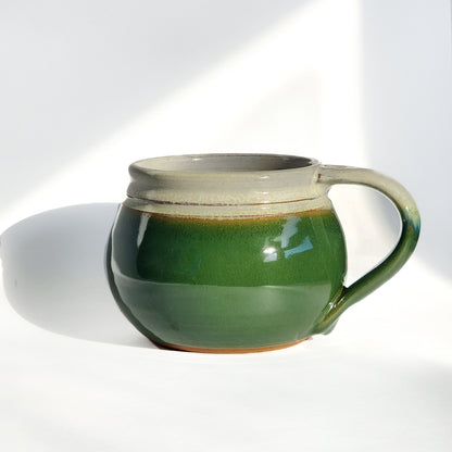 Image: Clinton Pottery's 24 oz Cereal/Soup Mug in Dark Green – A subtle and nature-inspired choice for your kitchen, this machine washable mug seamlessly blends artistry with functionality. The deep Dark Green color adds a touch of tranquility, reminiscent of lush forests and foliage. Perfect for savoring your favorite cereal or soup with a hint of natural elegance.