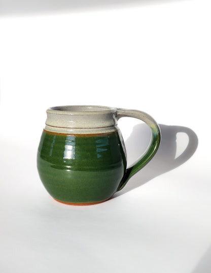  Image: Clinton Pottery's Handmade Medium Mug in Dark Green – A rich and versatile 14-16 oz mug, expertly crafted. This Dark Green piece adds a touch of earthy sophistication to your daily beverage routine, reminiscent of lush forest canopies and natural beauty.