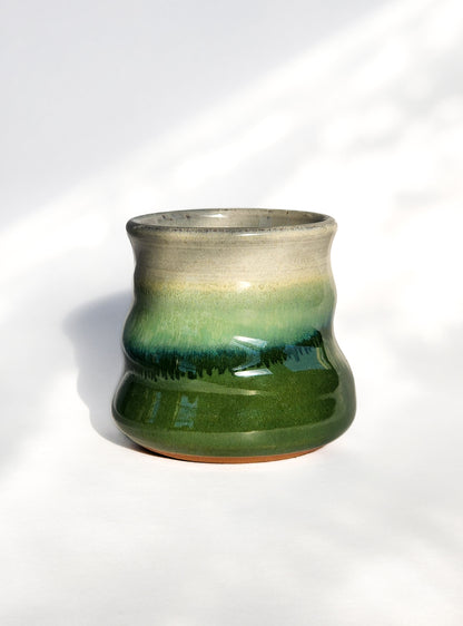 Image: Clinton Pottery's 8 oz Small Tumbler in Dark Green – A visually appealing addition with a cool, curvy design for a comfortable grip. This machine washable tumbler, crafted with care, adds contemporary elegance. The rich Dark Green color brings a touch of nature's depth, reminiscent of lush forests and evergreen landscapes.