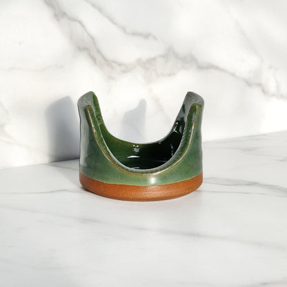 Image: Clinton Pottery's Handmade Sponge Holder in Dark Green – A rich and practical kitchen accessory, skillfully crafted by artisans. This durable stoneware holder, in deep Dark Green, brings a sense of natural elegance to your kitchen, reminiscent of lush forests and tranquility. Designed to securely hold your sponge and prevent water spread, it keeps your counters and sink area tidy.