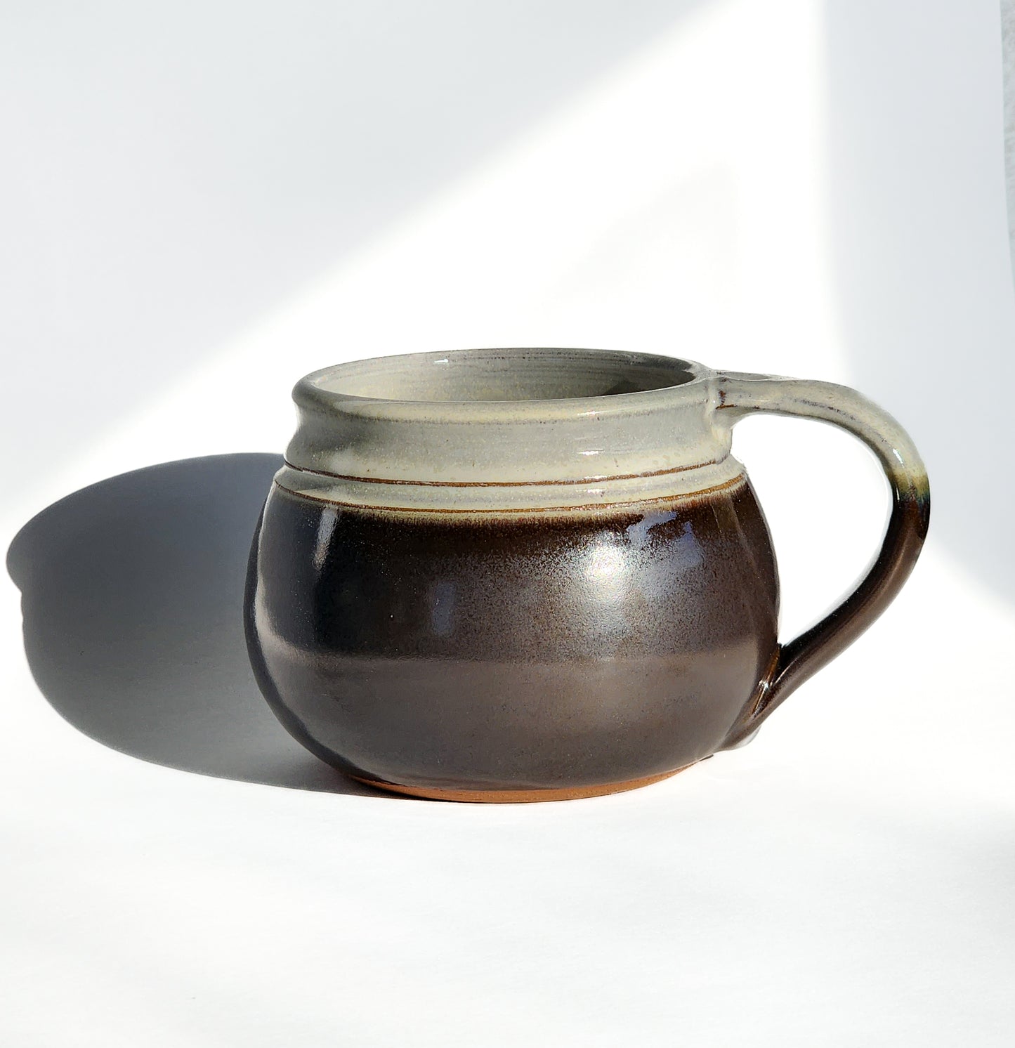Image: Clinton Pottery's 24 oz Cereal/Soup Mug in Licorice – A bold and sophisticated choice for your kitchen, this machine washable mug seamlessly blends artistry with functionality. The deep Licorice color adds a touch of mystery, reminiscent of midnight skies and refined elegance. Perfect for savoring your favorite cereal or soup with a dash of dramatic flair.
