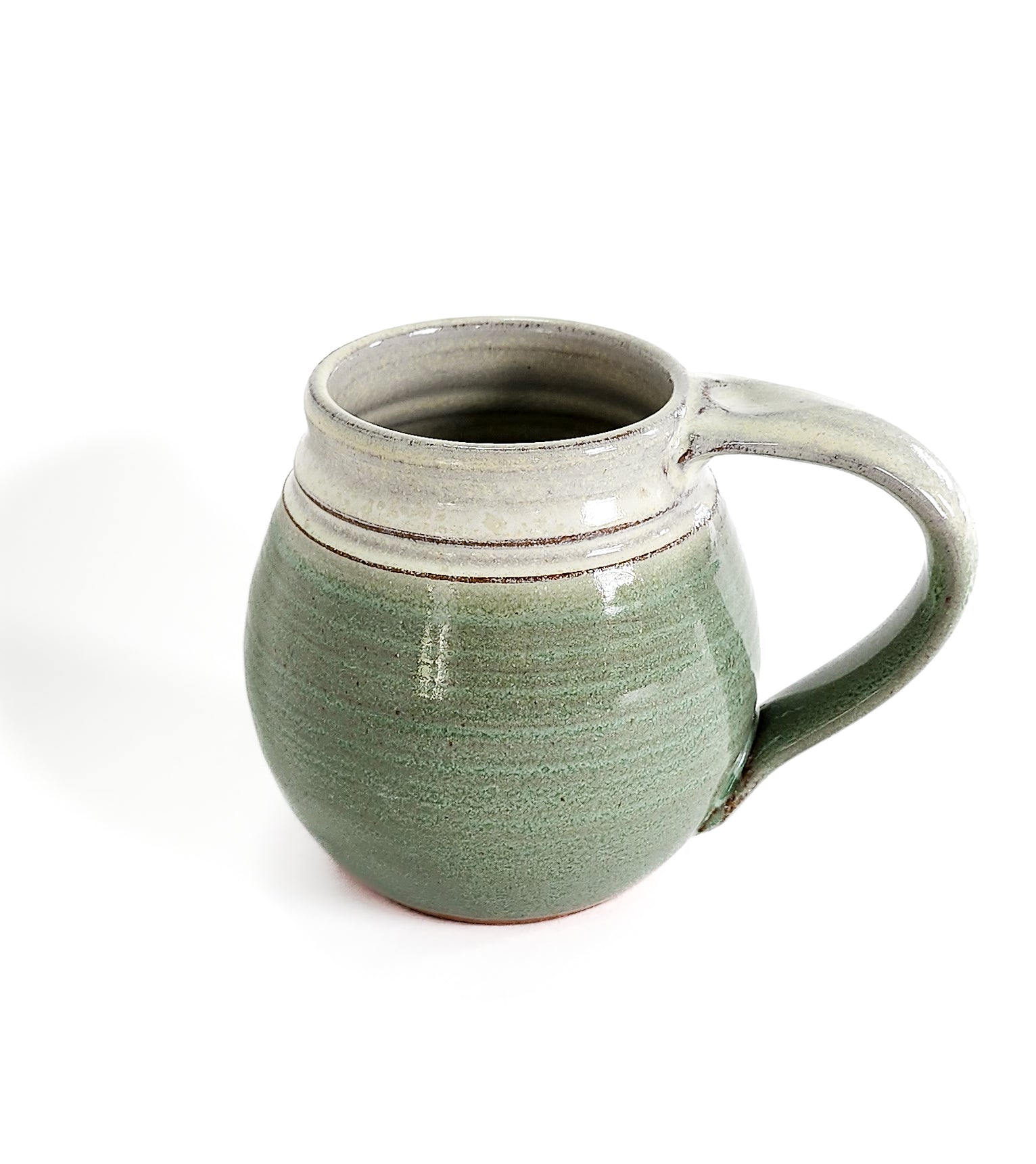 Image: Clinton Pottery's Handmade Medium Mug in Light Green – A refreshing and versatile 14-16 oz mug, expertly crafted. This Light Green piece adds a touch of natural vibrancy to your daily beverage routine, reminiscent of spring foliage and rejuvenation. 