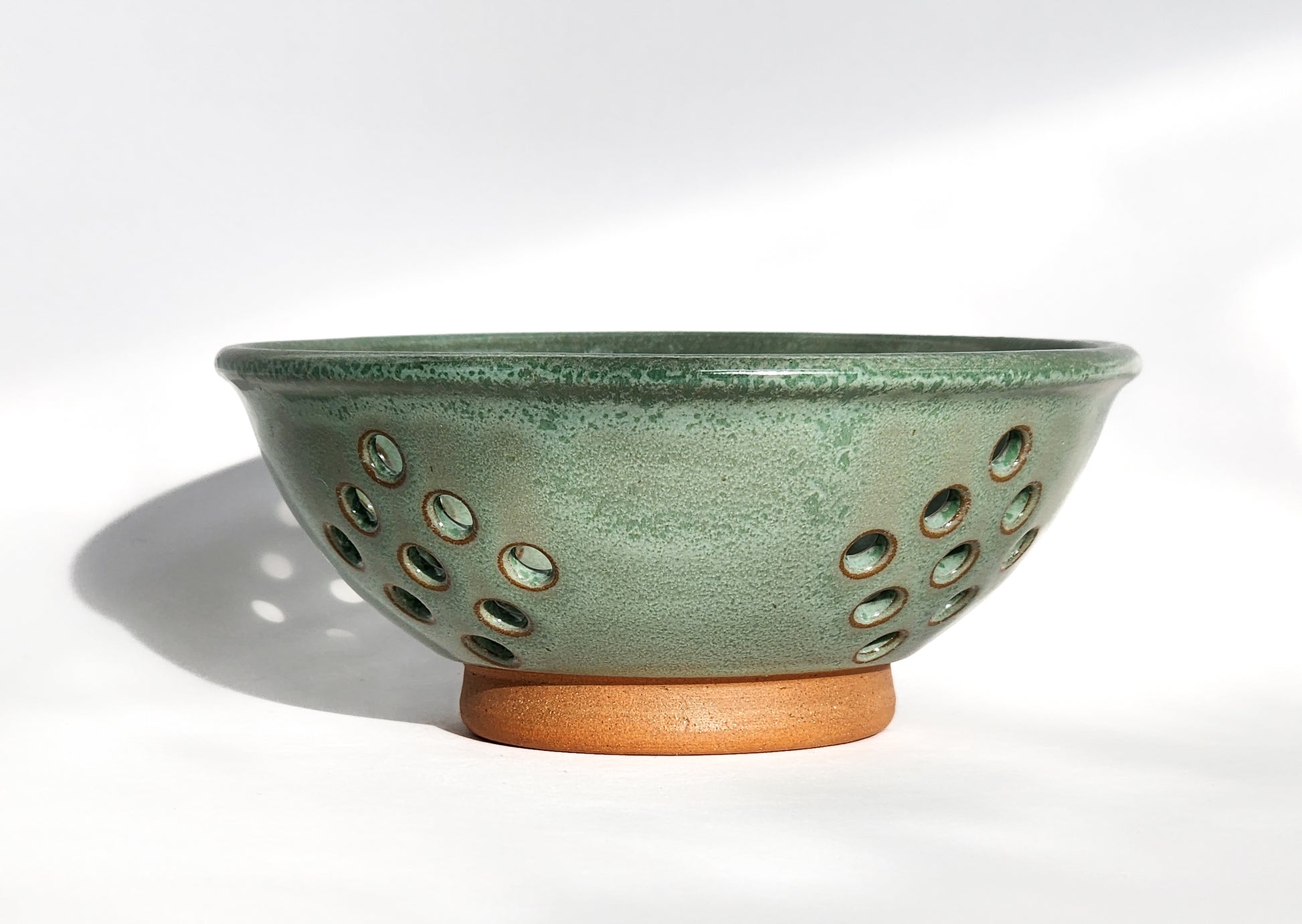 Image: Clinton Pottery's Handmade Small Colander in Light Green – A fresh and practical 2.25 cup colander, expertly crafted. This Light Green piece adds a touch of nature's vibrancy to your kitchen, reminiscent of spring foliage and the outdoors. Ideal for washing berries and smaller items, it seamlessly combines style with functionality. 