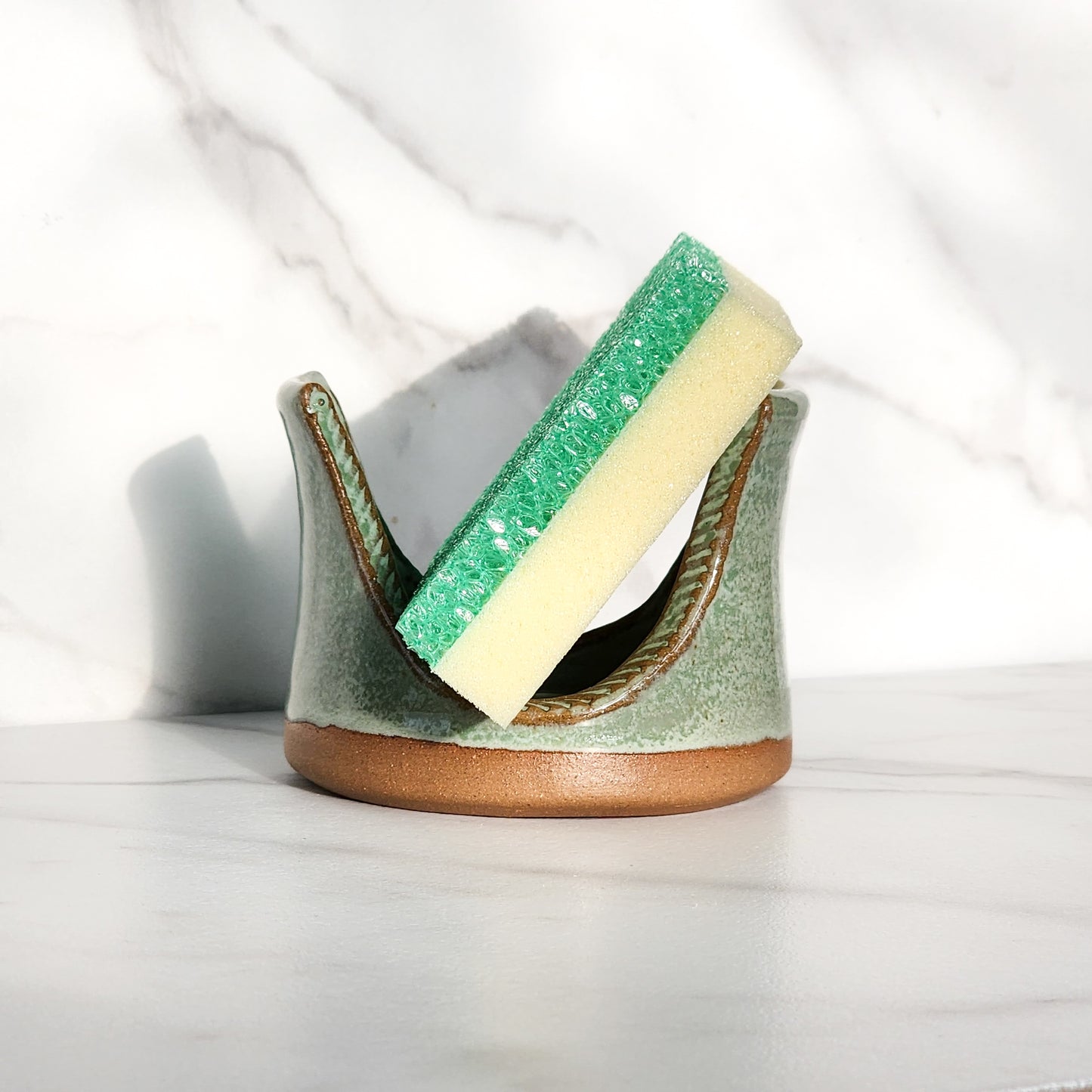  Image: Clinton Pottery's Handmade Sponge Holder in Light Green – A vibrant and practical kitchen accessory, carefully crafted by artisans. This durable stoneware holder, in refreshing Light Green, adds a touch of nature's vitality to your kitchen, reminiscent of spring foliage and growth. Designed to securely hold your sponge and prevent water spread, it keeps your counters and sink area tidy. 