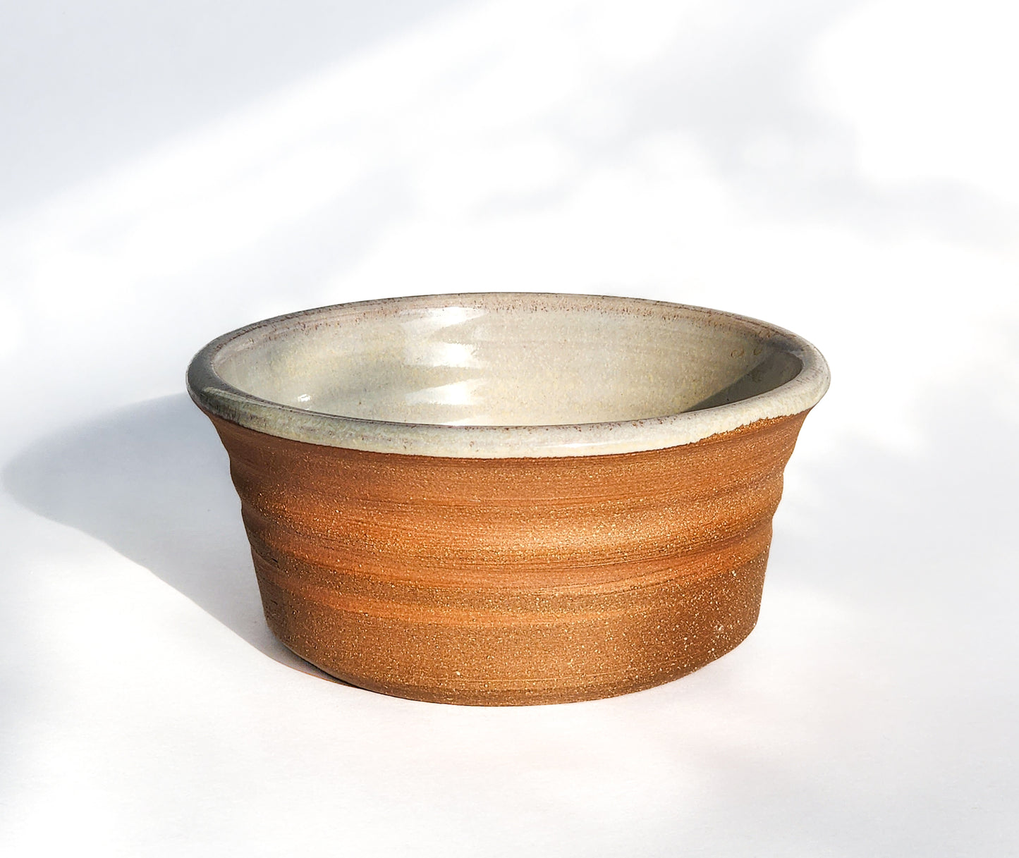 Image: Clinton Pottery's Handmade 1 Cup Flat Bottom Bowl in Natural (Unglazed) – Embracing simplicity and authenticity, this machine washable bowl combines artistry with a natural aesthetic. The unglazed exterior offers a raw and organic feel, reminiscent of earthen pottery and rustic charm. Ideal for serving snacks or adding a touch of elemental elegance to your culinary space.