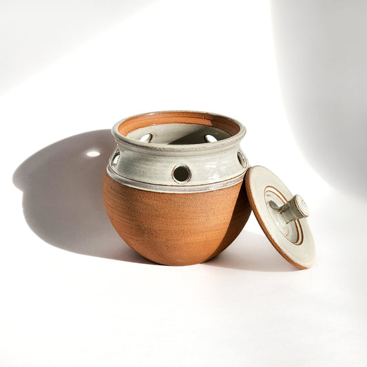 Image: A natural ceramic garlic keeper, unglazed (exterior) and designed to store garlic bulbs in a rustic style.