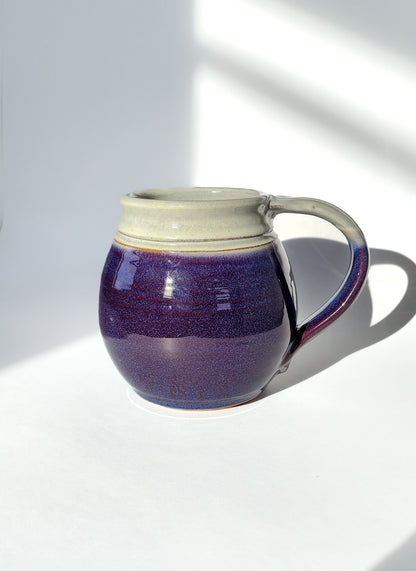 Image: Clinton Pottery's 30 oz Jumbo Mug in Purple – A regal and generously sized addition to your kitchen, this machine washable mug seamlessly blends artistry with functionality. The rich Purple color adds a touch of elegance, reminiscent of royal hues and blooming lavender fields. Perfect for enjoying ample servings of your favorite coffee or tea with a dash of majestic charm.