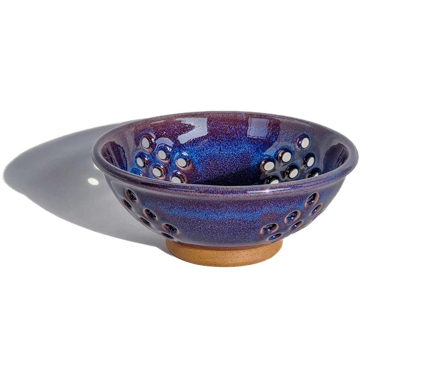  Image: Clinton Pottery's Handmade Small Colander in Purple – A regal and practical 2.25 cup colander, expertly crafted. This Purple piece adds a touch of royal elegance to your kitchen, reminiscent of majestic hues and sophisticated charm. Ideal for washing berries and smaller items, it seamlessly combines style with functionality. Machine washable for convenience, it's the perfect choice for those who appreciate practicality and aesthetics in a rich, captivating hue.