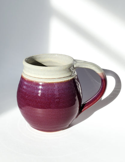 Image: Clinton Pottery's 30 oz Jumbo Mug in Red/Magenta – A vibrant and generously sized addition to your kitchen, this machine washable mug seamlessly blends artistry with functionality. The striking Red/Magenta color adds a burst of energy, reminiscent of ripe fruits and passionate hues. Perfect for enjoying ample servings of your favorite coffee or tea with a pop of bold sophistication.