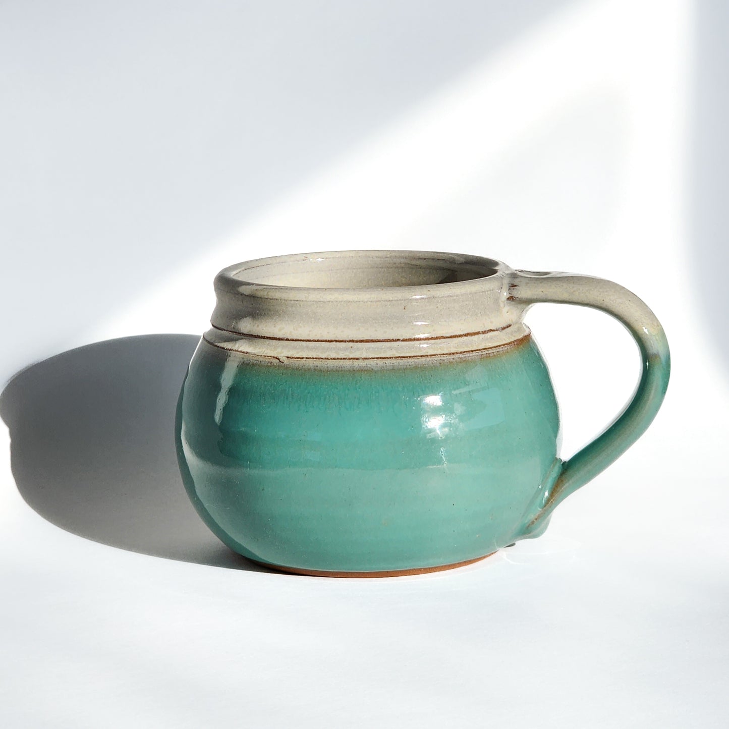 Image: Clinton Pottery's 24 oz Cereal/Soup Mug in Sky Blue – A serene and refreshing choice for your kitchen, this machine washable mug seamlessly blends artistry with functionality. The soothing Sky Blue color adds a touch of tranquility, reminiscent of clear skies and calming waters. Perfect for enjoying your favorite cereal or soup, bringing a breath of peaceful elegance to your dining experience.