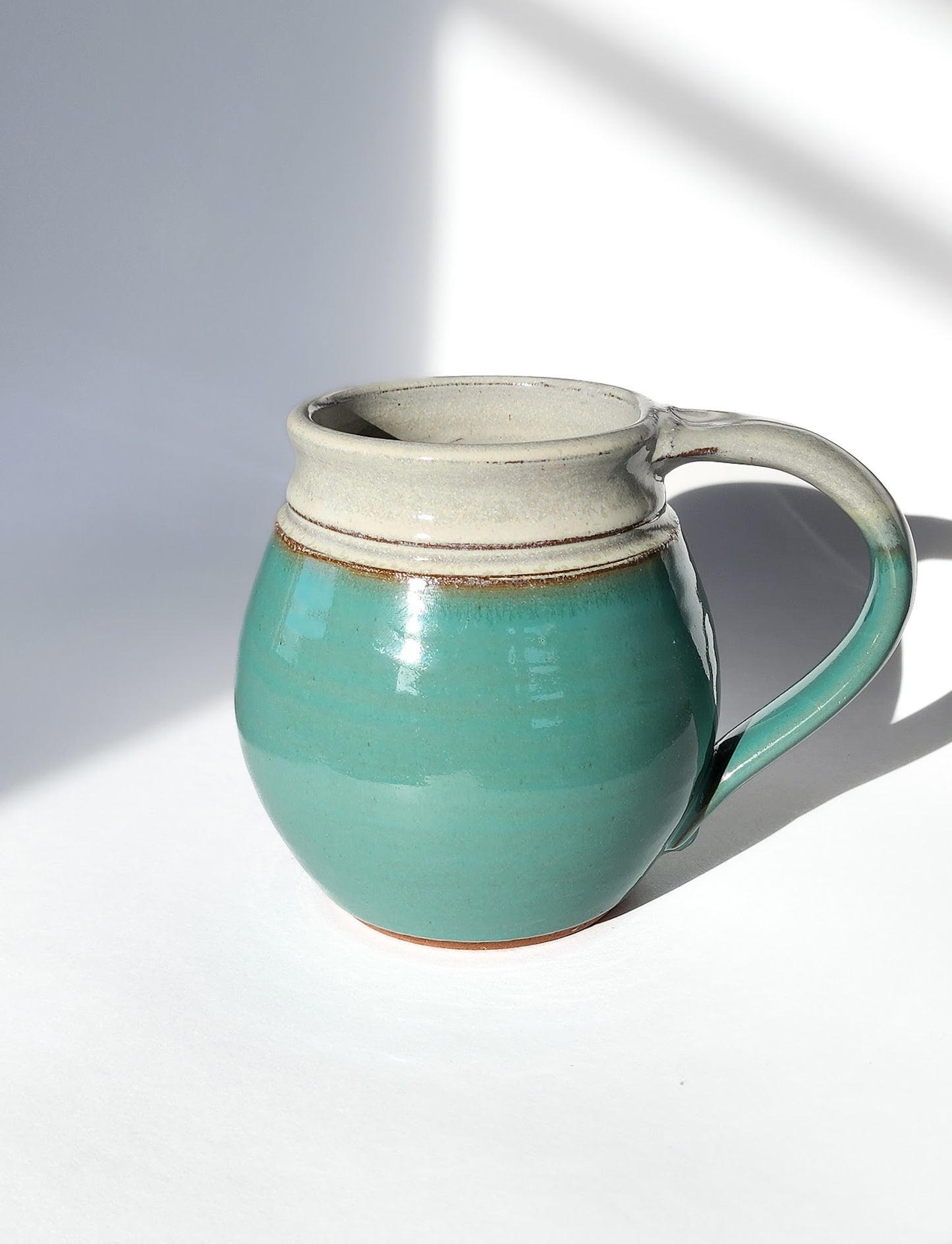 Image: Clinton Pottery's 30 oz Jumbo Mug in Sky Blue – A serene and generously sized addition to your kitchen, this machine washable mug seamlessly blends artistry with functionality. The soothing Sky Blue color adds a touch of tranquility, reminiscent of clear skies and calming waters. Perfect for enjoying ample servings of your favorite coffee or tea with a breath of peaceful charm.