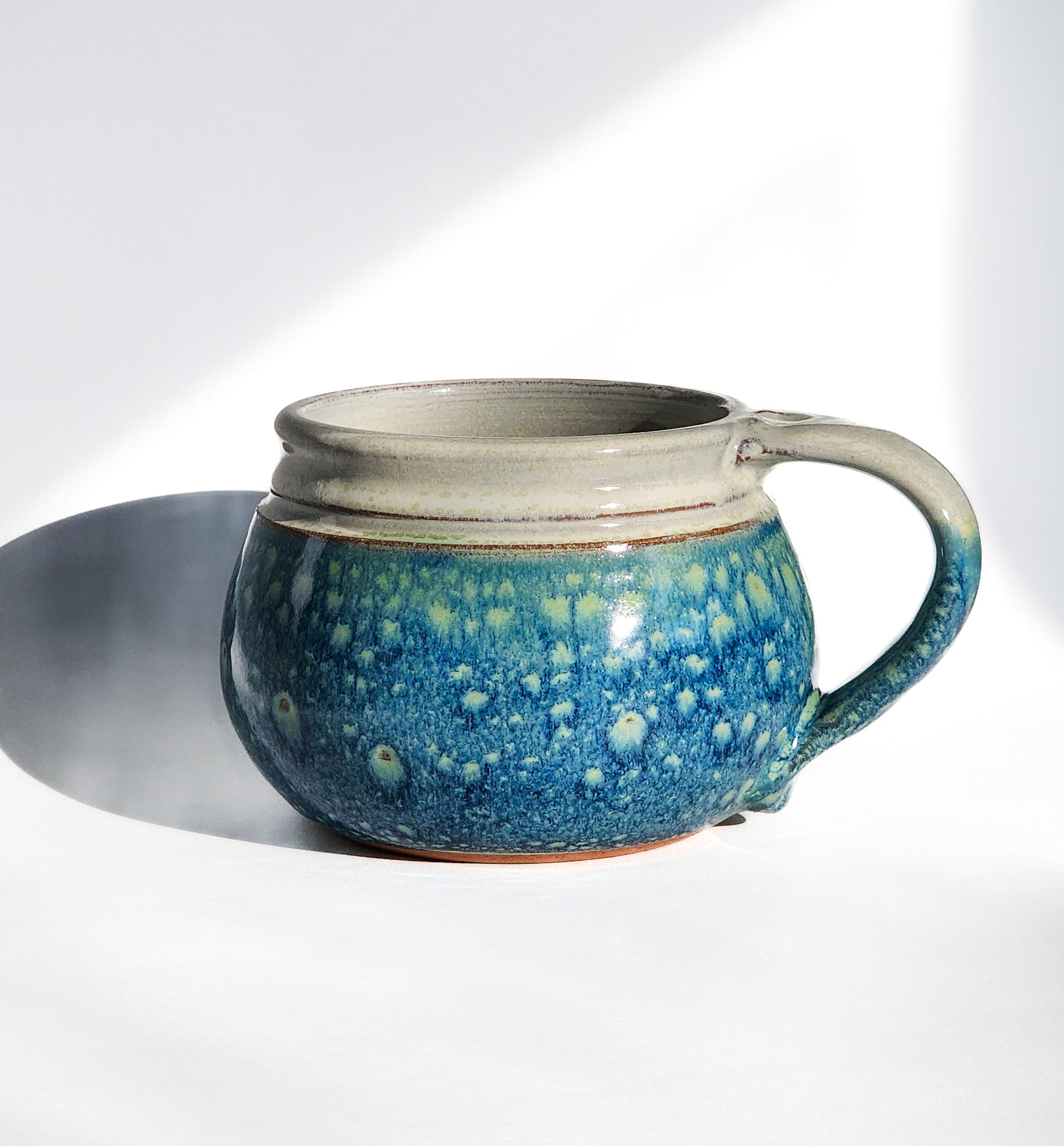 Image: Clinton Pottery's 24 oz Cereal/Soup Mug in Starry Night – A celestial and enchanting addition to your kitchen, this machine washable mug seamlessly blends artistry with functionality. The captivating Starry Night color evokes the magic of the night sky, reminiscent of Van Gogh's swirling stars and cosmic wonder. Perfect for enjoying your favorite cereal or soup with a touch of celestial elegance.