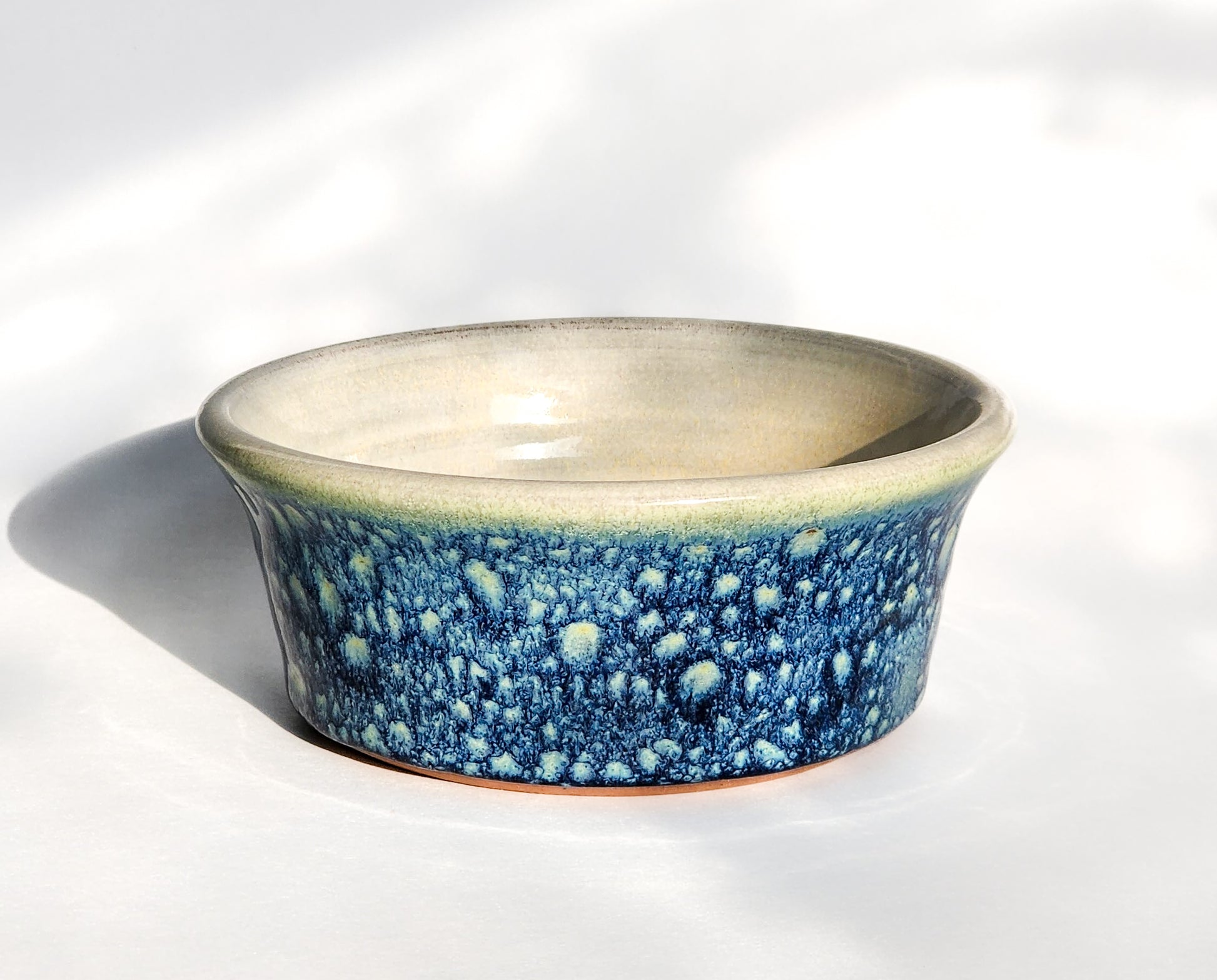 Image: Clinton Pottery's Handmade 1 Cup Flat Bottom Bowl in Starry Night – Inspired by the ethereal beauty of Van Gogh's Starry Night, this machine washable bowl seamlessly merges artistry with practicality. The enchanting Starry Night color evokes the magic of the iconic masterpiece, reminiscent of Van Gogh's swirling stars and cosmic wonder. Perfect for serving snacks or adding a touch of celestial elegance to your culinary space.