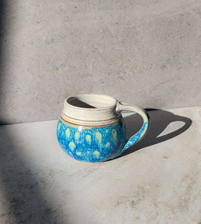  Image Description: A small mug in the "Starry Night" color from Clinton Pottery is featured against a neutral background. The mug boasts a deep, rich hue reminiscent of a starry sky, with specks of white and gold swirling throughout. Its curved shape and sturdy handle offer both elegance and functionality. Perfect for enjoying a cozy cup of coffee or tea, this mug adds a touch of celestial beauty to your morning routine.