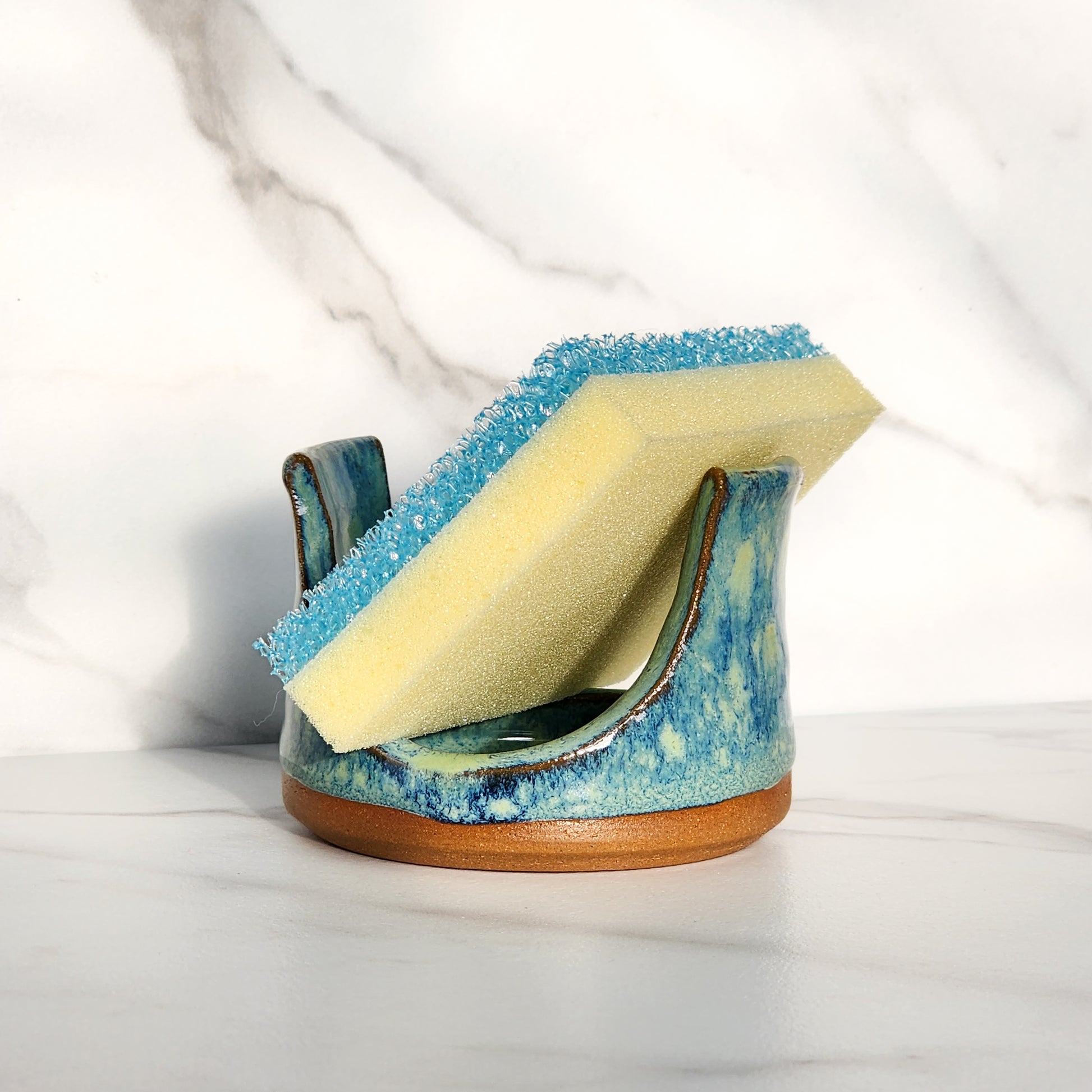  Image: Clinton Pottery's Handmade Sponge Holder in Starry Night – An enchanting and practical kitchen accessory, expertly crafted by artisans. This durable stoneware holder, in mesmerizing Starry Night, adds a touch of celestial beauty to your kitchen, reminiscent of Van Gogh's masterpiece. Designed to securely hold your sponge and prevent water spread, it keeps your counters and sink area tidy. 
