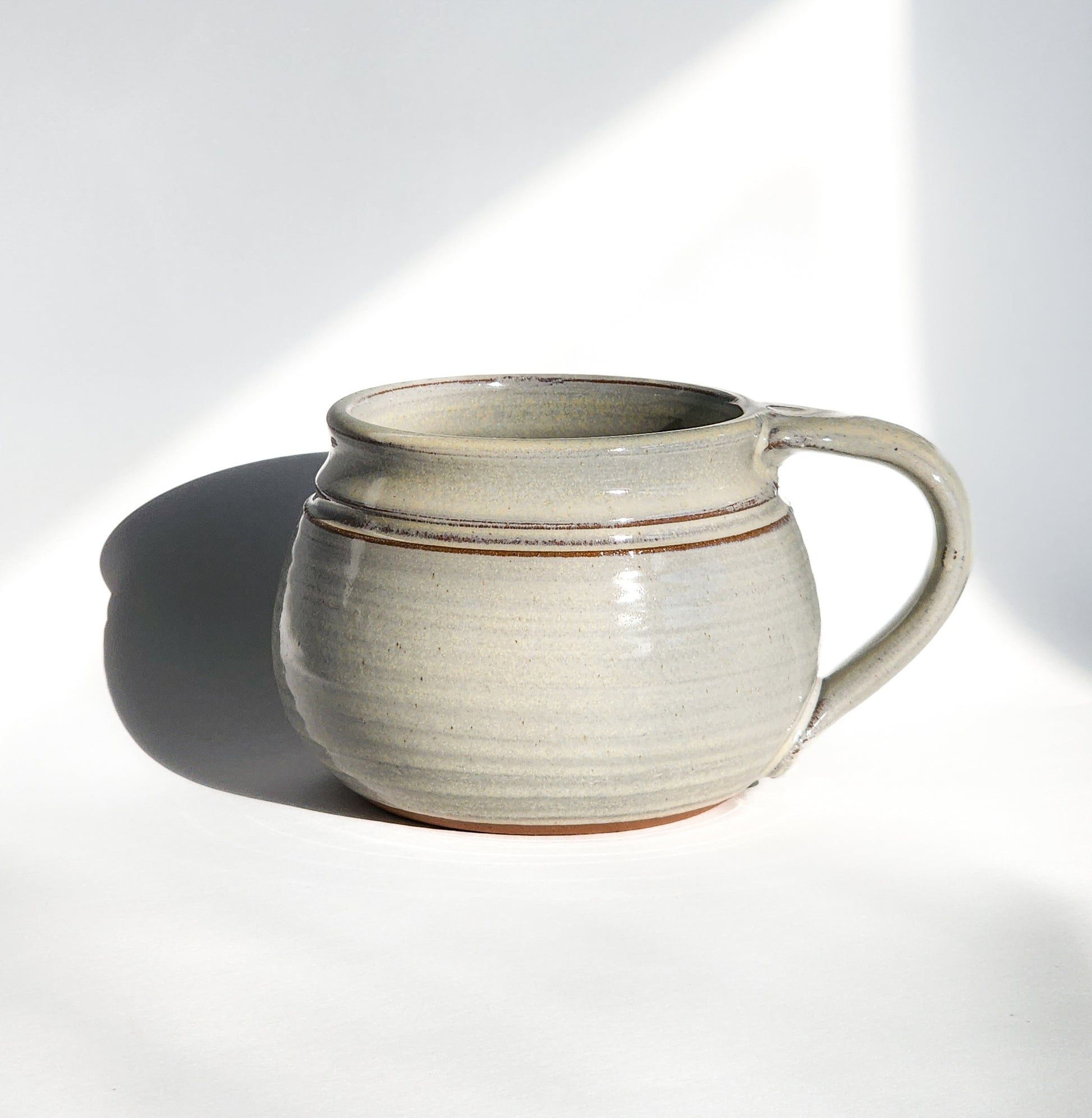Image: Clinton Pottery's 24 oz Cereal/Soup Mug in White – A classic and versatile addition to your kitchen, this machine washable mug seamlessly blends artistry with functionality. The timeless White color adds a clean and neutral touch, reminiscent of simplicity and clarity. Perfect for enjoying your favorite cereal or soup, bringing an understated elegance to your dining experience.