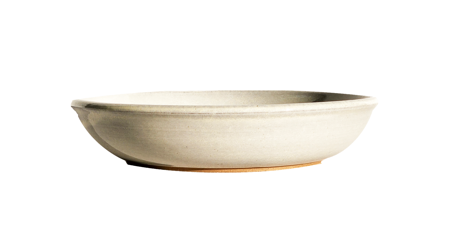  Image Description: A large pasta dish in a crisp white glaze, made by Clinton Pottery. This 10-inch dish is perfect for serving ample portions of pasta or other delicious meals, adding a touch of timeless elegance to any table setting.